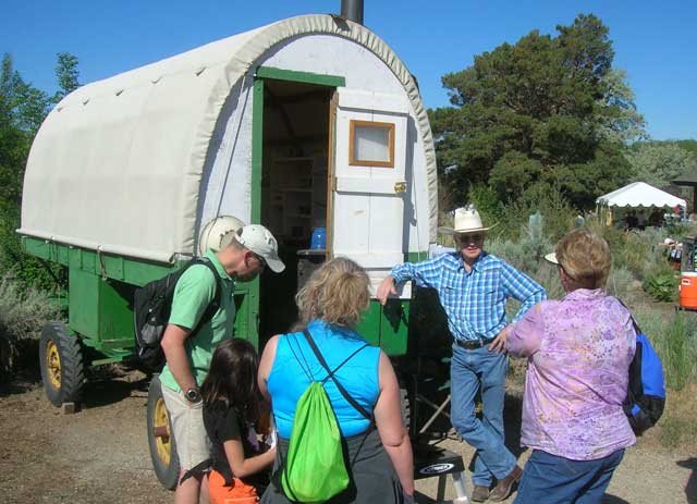 James England talks to folks about sheep camp wagons. England’s father refurbished this one on display